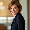 Ritratto sorridente di Anna M., una donna milanese di 48 anni elegante e dall'aspetto energico, che irradia fiducia nel suo ambiente professionale.